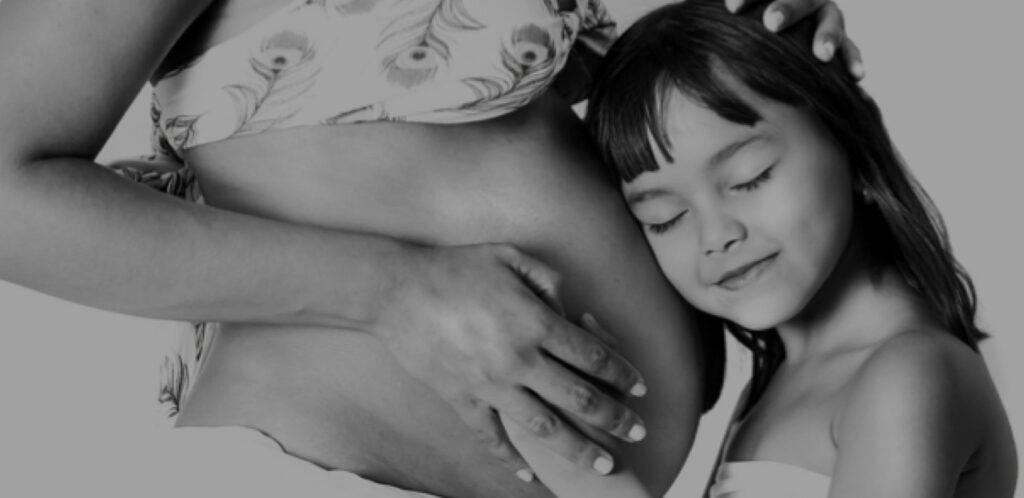 Daughter holding pregnant mom stomach